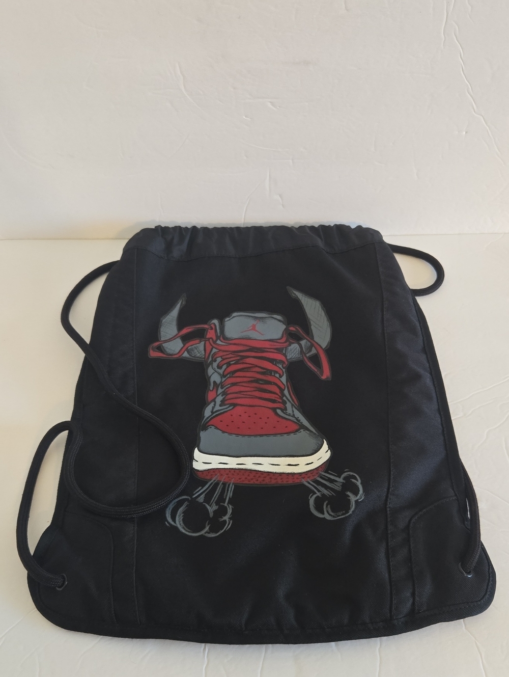 Jordan Black Drawstring Backpack with Red and Gray Sneaker Graphic